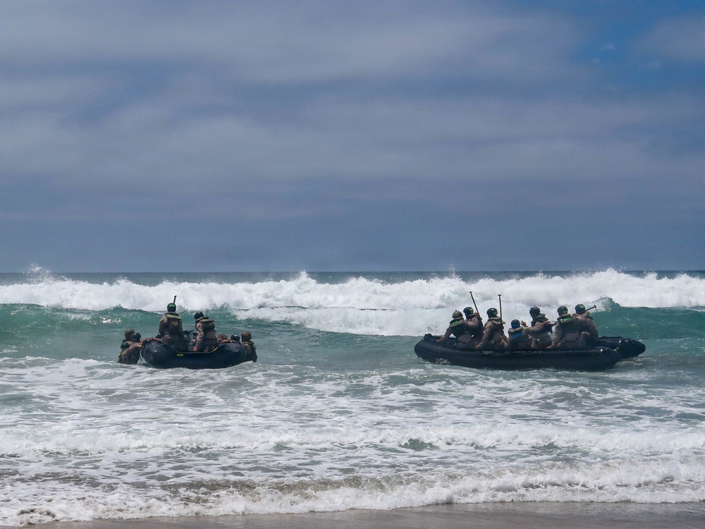 2nd Bn., 5th Marines, paddle through surf during infantry company small boat raid course