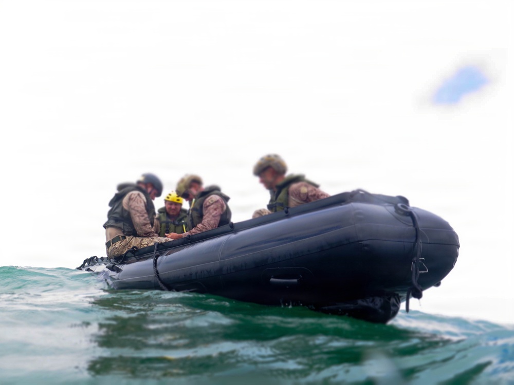 2nd Bn., 5th Marines, paddle through surf during infantry company small boat raid course