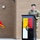 A U.S. Army officer in MultiCam/OCP uniform and green beret is speaking at a podium during an official military ceremony. The podium displays the 'NOMADS' unit designation along with what appears to be a 3rd Special Forces Group insignia in yellow, red, and white colors. A red general officer's flag with a single star is visible to the left, indicating a Brigadier General is present.