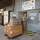 A U.S. Army soldier in camouflage uniform is moving a pallet cart loaded with cardboard boxes outside the Camp Bondsteel Military Postal Service facility, APO AE 09240. The facility is associated with KFOR (Kosovo Force) operations, as indicated by the signage. The soldier appears to be handling incoming or outgoing mail and packages.