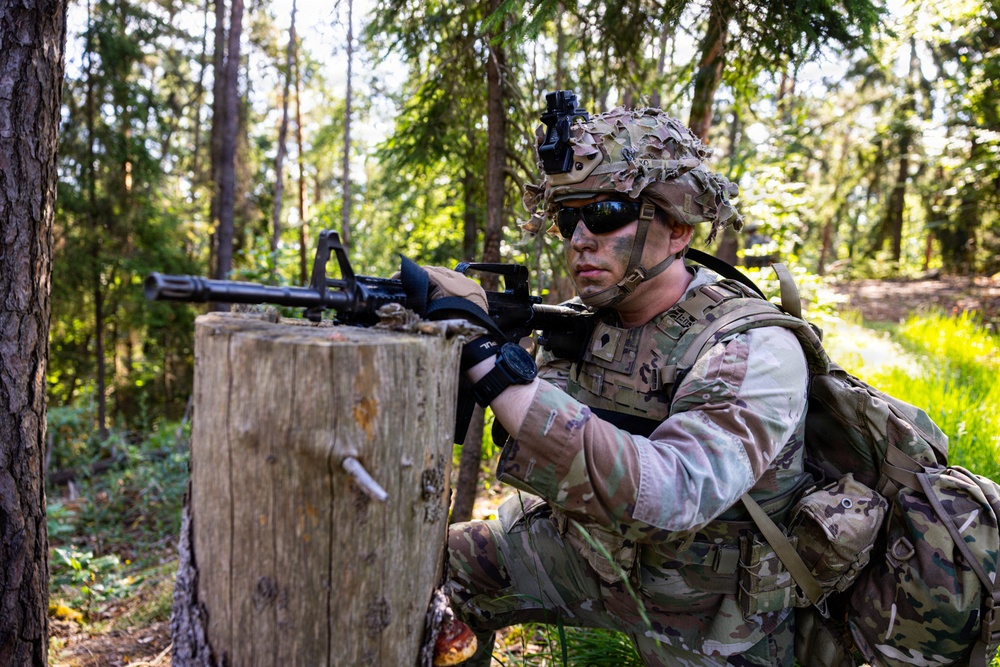U.S. Army Soldier takes cover behind log obstacle during Spectrum Blitz 26