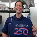 U.S Coast Guard Petty Officer 2nd Class Starner holds America 250 commemorative flag