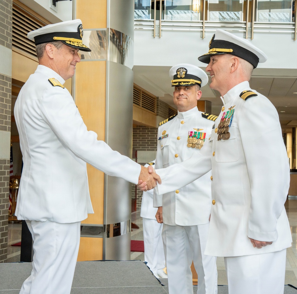 Rear Adm. Tony Rossi, left, shakes hands with incoming PMA-260 program manager Capt. James Bailey at PMA-260 change of command ceremony