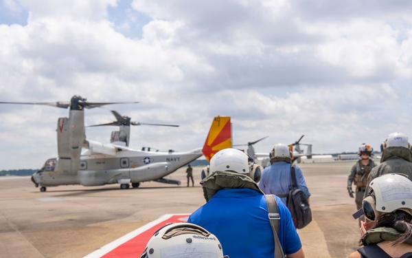 Vice Adm. Doug Perry, commander, U.S. 2nd Fleet, alongside members of the media, boards a CMV-22B Osprey