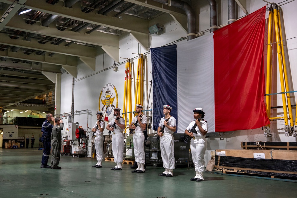 Vice Adm. Doug Perry, commander, U.S. 2nd Fleet, salutes French navy sailors alongside Capt. Jocelyn Delrieu