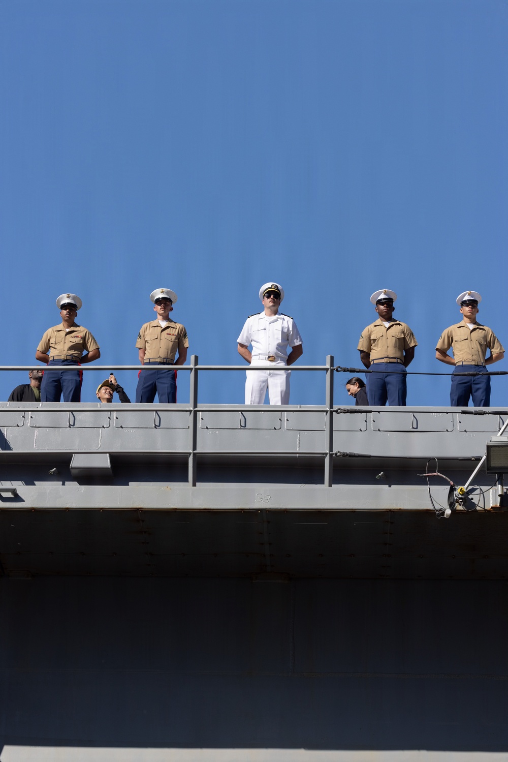 U.S. Marines and Sailors man the rails aboard the USS Arlington (LPD-24)