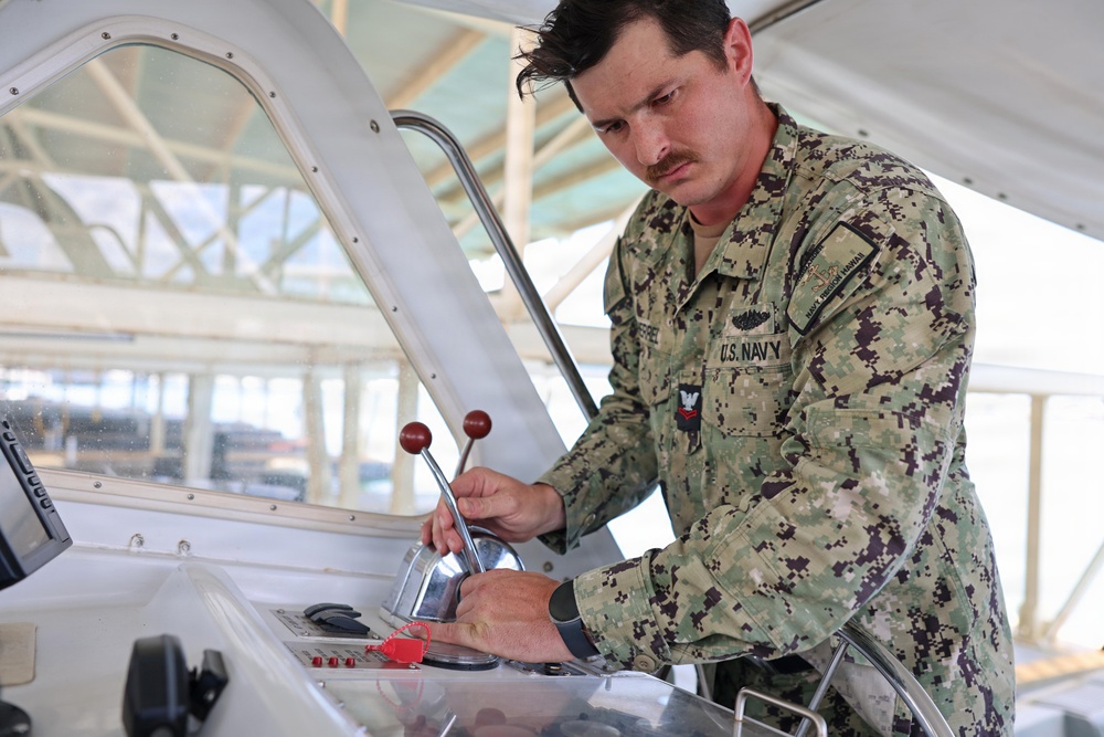 U.S. Navy Machinist’s Mate 2nd Class Zackery Herrel conducts a pre-underway maintenance check on the historic admiral's barge at Joint Base Pearl Harbor-Hickam