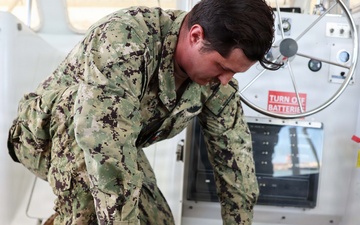 U.S. Navy Machinist’s Mate 2nd Class Zackery Herrel secures the engine hatches on the historic admiral's barge during routine maintenance at Joint Base Pearl Harbor-Hickam.