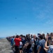 Sailors' Friends And Family Members Watch C-2A Greyhound Flyby