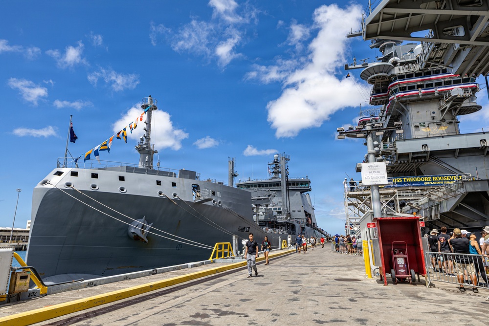 Royal New Zealand Navy vessel and U.S. Navy aircraft carrier moor at Joint Base Pearl Harbor-Hickam for RIMPAC 26