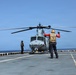 A U.S. Sailor signals a UH-1Y Venom helicopter, assigned to Marine Medium Tiltrotor Squadron (VMM) 365 (Reinforced), Littoral Combat Force 24.