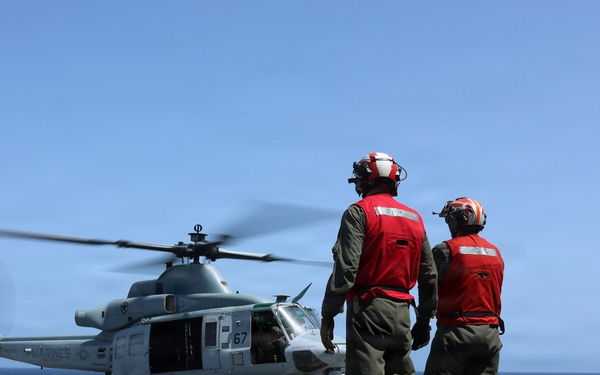 U.S. Marines signal a UH-1Y Venom helicopter, assigned to Marine Medium Tiltrotor Squadron (VMM) 365 (Reinforced), Littoral Combat Force 24.