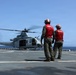 U.S. Marines signal a UH-1Y Venom helicopter, assigned to Marine Medium Tiltrotor Squadron (VMM) 365 (Reinforced), Littoral Combat Force 24.