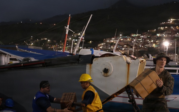 U.S. Sailors and Marines, with Littoral Combat Force 24, unload Meals, Ready-to-Eat boxes from Landing Craft Utility (LCU) 1662, assigned to Assault Craft Unit (ACU) 2, in La Guaira, Venezuela, June 27, 2026.