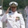A U.S. Navy officer in white dress uniform is rendering a salute during what appears to be a formal military ceremony, likely a change of command or sideboy honors on a pier or dock. The central officer displays multiple medals and decorations along with gold shoulder boards indicating senior rank. Several other naval personnel in white dress uniforms flank him, also saluting.