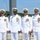 USS South Dakota (SSN 790) Holds Change of Command Ceremony Four U.S. Navy officers in dress white uniforms are posed together outdoors at what appears to be a naval facility or pier. All four are smiling and wearing white service dress uniforms adorned with medals, ribbons, and rank insignia. The setting suggests a formal military ceremony or official event.