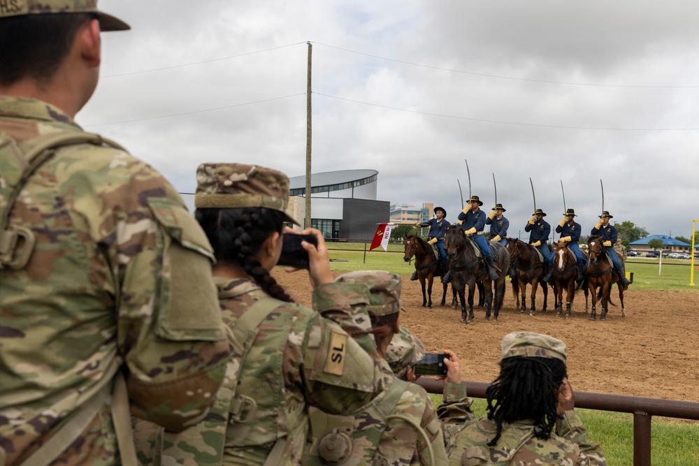 Reserve Officers' Training Corps (JROTC) watch 1st Cavalry Division Horse Cavalry Detachment demonstration