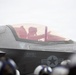 A military pilot is seated in the cockpit of an F-35 fighter jet, designated aircraft number 02, assigned to Capt. J.J. 'STORQ' Metzger. The aircraft displays standard U.S. military markings including a roundel and safety/rescue stenciling. Ground crew personnel wearing helmets are visible in the foreground, suggesting pre-flight or taxiing operations.