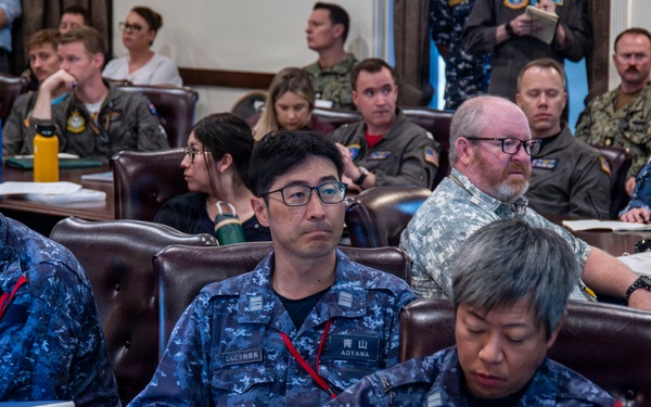 Multinational service members review a SINKEX brief during Exercise Rim of the Pacific 26