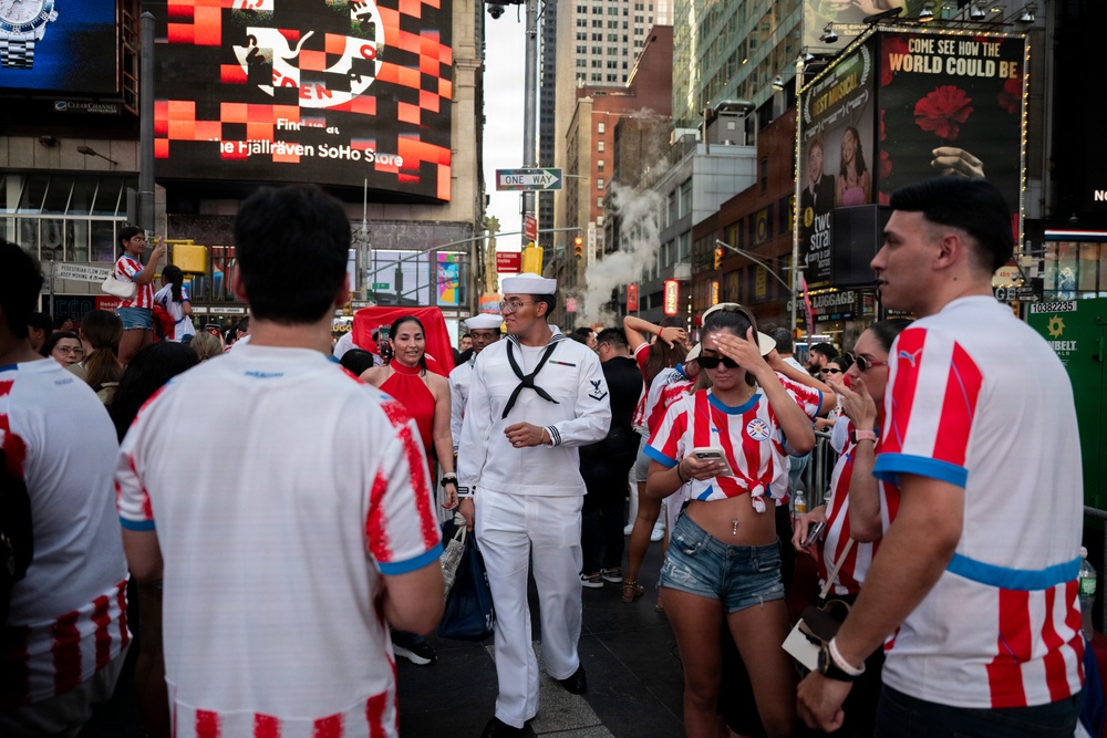 U.S. Navy sailor walks through Times Square during Sail 250