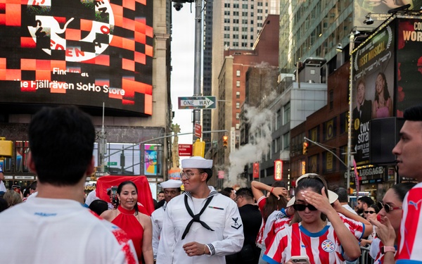 U.S. Navy sailor walks through Times Square during Sail 250