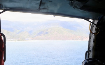 A U.S. Naval Aircrewman (Helicopter) scans the horizon from an MH-60R Seahawk, assigned to Helicopter Maritime Strike Squadron (HSM) 48.