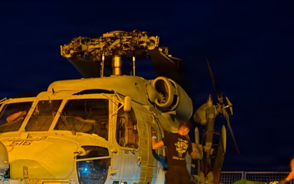 Sailors secure an MH-60R Seahawk helicopter, assigned to Helicopter Maritime Strike Squadron (HSM) 48, to the flight deck.