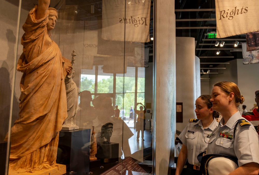 U.S. Coast Guard members view an exhibit inside the Statue of Liberty Museum