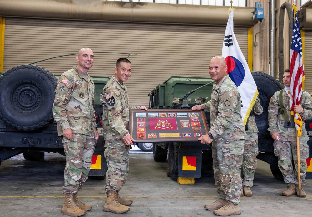 Lt. Col. Frederick T. Dequina, outgoing commander, poses for a photo after receiving the farewell plaque from the 25th Transportation Battalion.