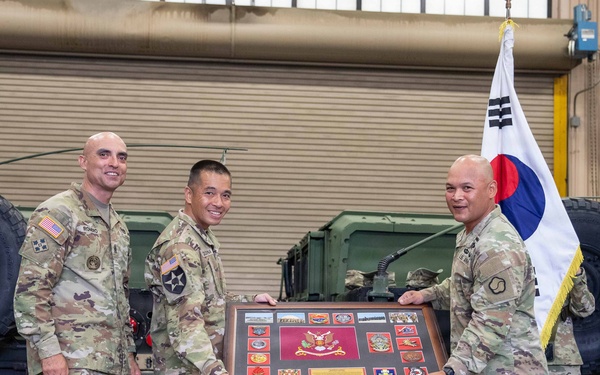 Lt. Col. Frederick T. Dequina, outgoing commander, poses for a photo after receiving the farewell plaque from the 25th Transportation Battalion.