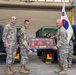 Lt. Col. Frederick T. Dequina, outgoing commander, poses for a photo after receiving the farewell plaque from the 25th Transportation Battalion.