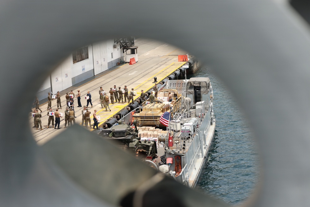 U.S. Marines, with 3rd Battalion, 2nd Marine Regiment, Littoral Combat Force-24, and U.S. Sailors, with San Antonio-class amphibious transport dock USS Fort Lauderdale (LPD 28), load supplies.