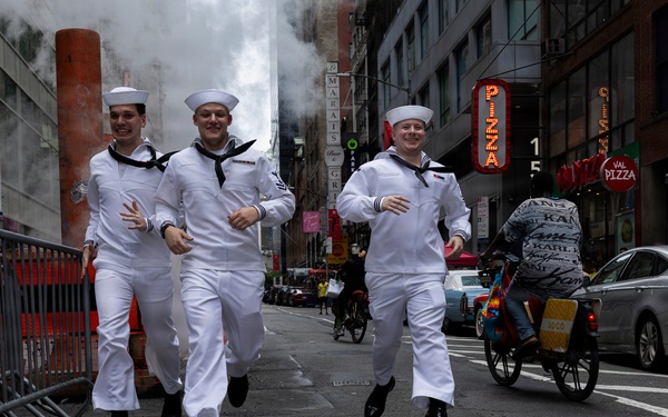 .S. Navy Sailors run near Times Square in New York while celebrating International Naval Review