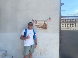 U.S. Army Capt. Javier Pino, with U.S. Army Veterinary Readiness Activity, Rheinland-Pfalz, poses beside a plaque honoring Col. William O. Darby.