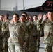 A group of U.S. Army soldiers in OCP (Operational Camouflage Pattern) uniforms are raising their right hands, appearing to take an oath or pledge. The ceremony is taking place inside a military hangar, with a fighter jet bearing '177 FW' (177th Fighter Wing) markings visible in the background. Name tapes visible on soldiers include 'VALDEZ' and 'CARLOS'.