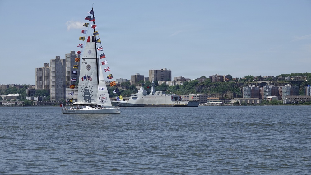 A French Naval Academy sailing vessel displays signal flags as it transits the Hudson River near the Royal Moroccan Navy frigate RMNS Mohammed VI (701) during International Naval Review 250.