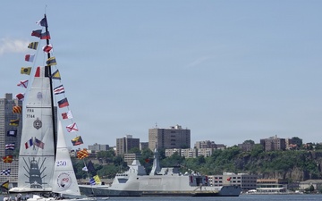 A French Naval Academy sailing vessel displays signal flags as it transits the Hudson River near the Royal Moroccan Navy frigate RMNS Mohammed VI (701) during International Naval Review 250.
