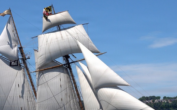Tall ship Pride of Baltimore II transits the Hudson River during International Naval Review 250 as a U.S. Coast Guard response boat operates nearby and the Royal Moroccan Navy frigate RMNS Mohammed VI (701) is visible in the background