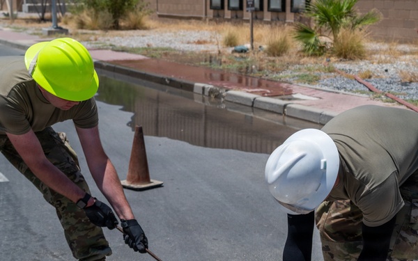 Cable specialists conduct maintenance hole inspection to support base operations