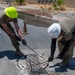 Cable specialists conduct maintenance hole inspection to support base operations