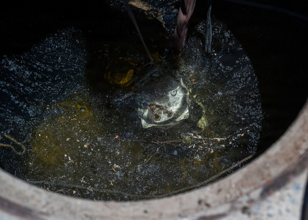 Cable specialists conduct maintenance hole inspection to support base operations