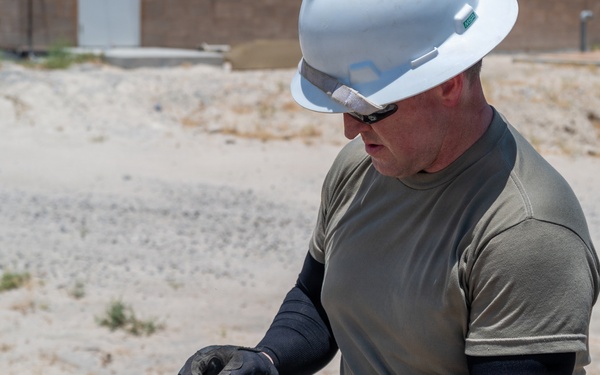 Cable specialists conduct maintenance hole inspection to support base operations