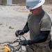 Cable specialists conduct maintenance hole inspection to support base operations