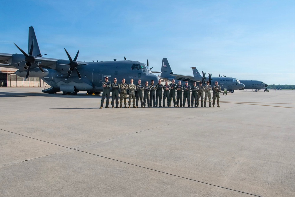 U.S. Air Force airmen pose with C-130 Hercules aircraft on flight line