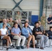 Family members and military personnel attend ceremony inside aircraft hangar