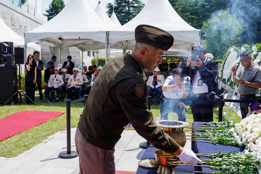Pak places a flower in tribute