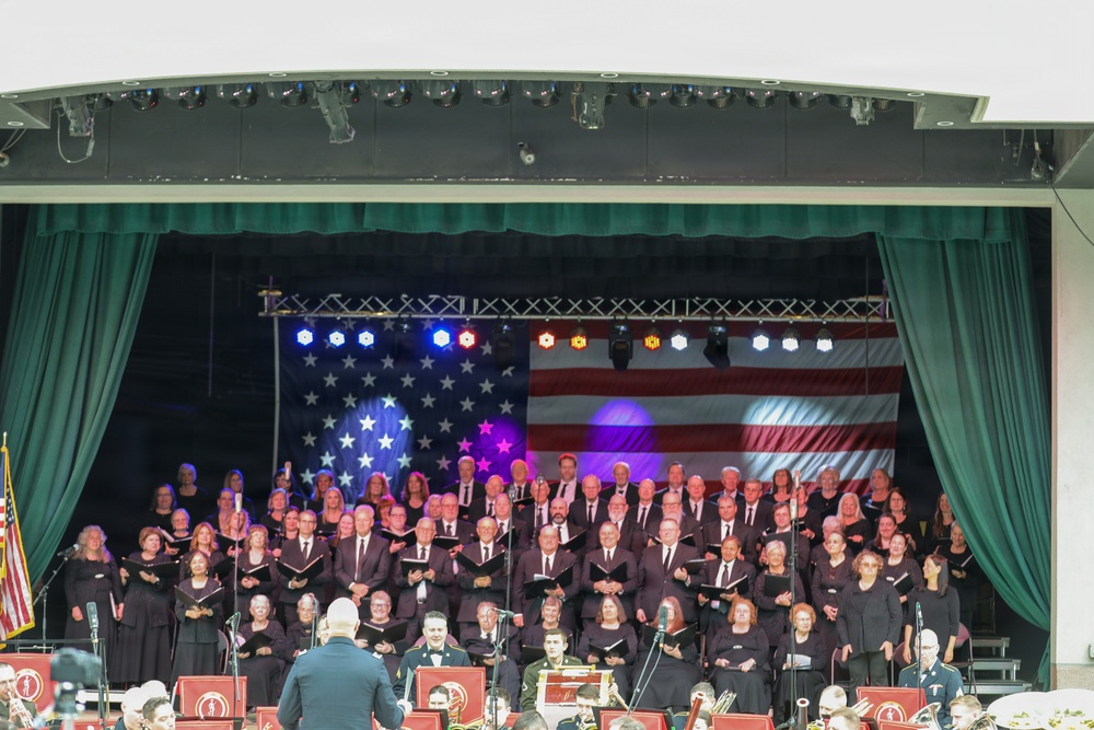 Military Choir and Band Perform Patriotic Concert Before Large American Flag Backdrop