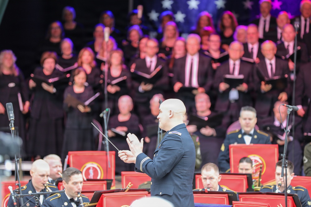 U.S. Army conductor leads military band and civilian choir during patriotic concert performance