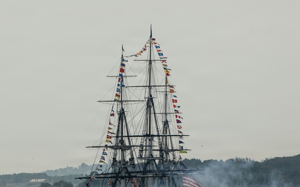 USS Constitution renders a gun salute during the Sail250 Boston Parade of Sail