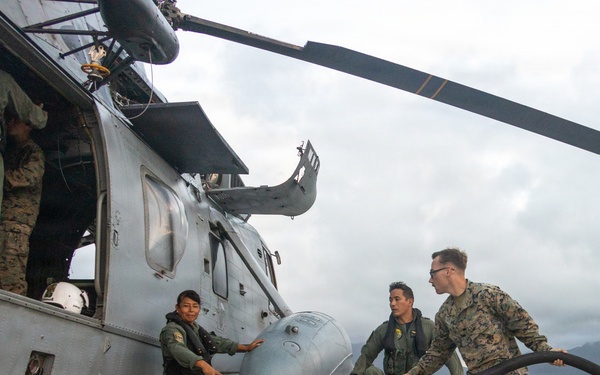 U.S. Marines, Peruvian Navy service members refuel SH-3 Sea King helicopter